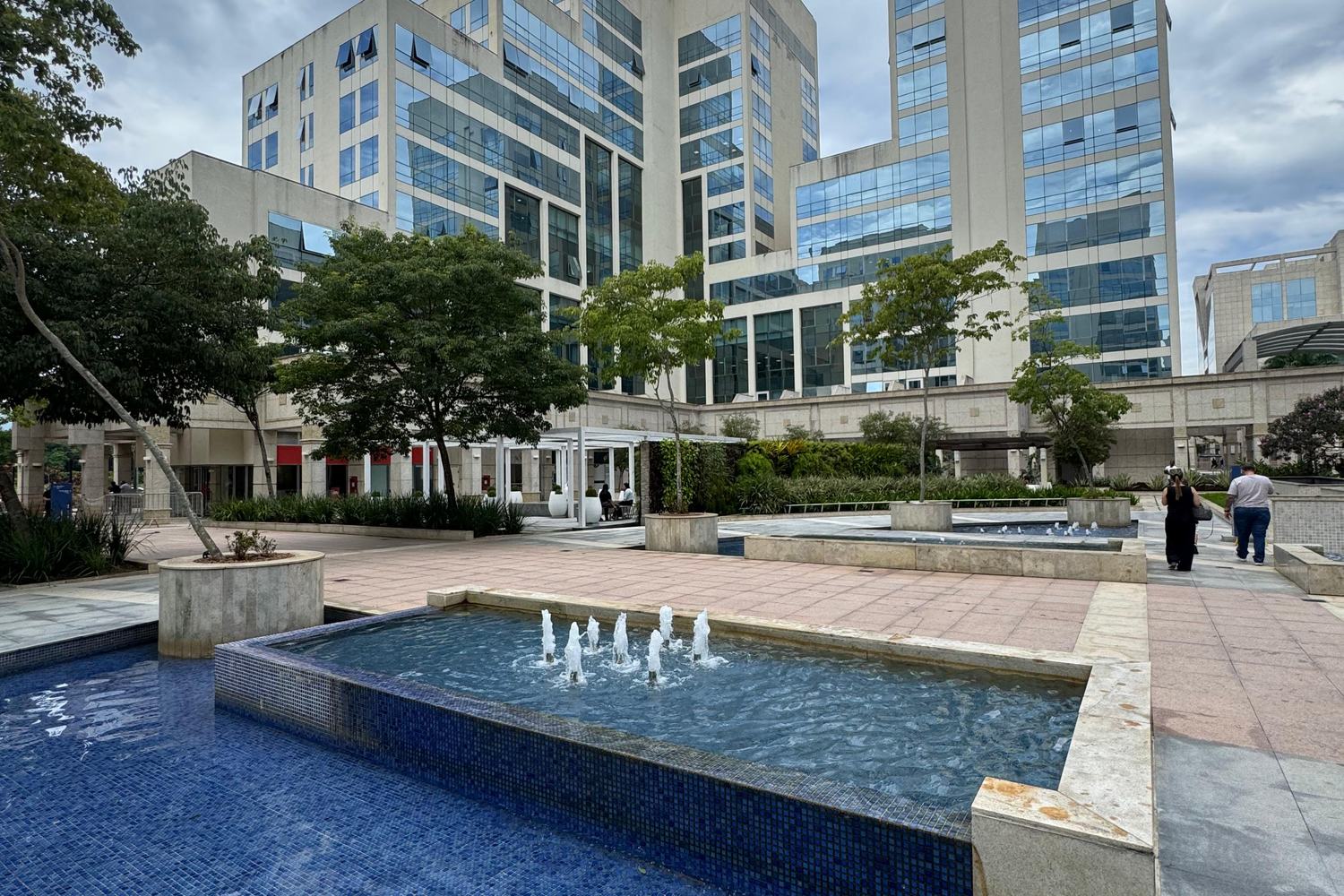 Praça com espelho d'água em frente ao One World Offices